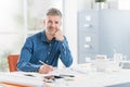 Professional architect sitting at office desk and working, he is checking a project blueprint, engineering and architecture Royalty Free Stock Photo