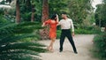 Professional artists dancing latin american dance in garden. Partners performing Royalty Free Stock Photo
