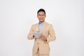 A professional Asian businessman is standing on an isolated white background with a digital tablet Royalty Free Stock Photo
