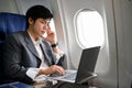 Professional Asian businessman working on his project, using laptop during the flight Royalty Free Stock Photo