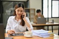 Professional Asian businesswoman focused on a call with her client in the office Royalty Free Stock Photo