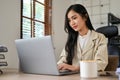 Professional Asian businesswoman focused on her financial online report on her laptop