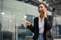 Professional Asian businesswoman is on the phone with business partner at outside of the building Royalty Free Stock Photo