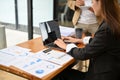 Professional Asian businesswoman working on her financial data on laptop with her team Royalty Free Stock Photo