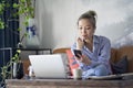 Mature asian woman working from home using laptop computer and cellphone Royalty Free Stock Photo