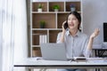 Professional Asian female accountant focuses on her sales accounts using a calculator and laptop Royalty Free Stock Photo