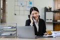 Professional Asian female accountant focuses on her sales accounts using a calculator and laptop Royalty Free Stock Photo