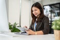 A professional Asian female call centre operator with a wireless headset using her digital tablet Royalty Free Stock Photo