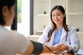 A professional Asian female doctor checking patient's pulse, heart rate and blood pressure Royalty Free Stock Photo