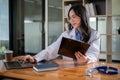 A professional Asian female doctor is working on her laptop at a table in her office at a hospital Royalty Free Stock Photo