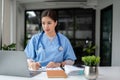 A professional Asian female doctor is working and reading medical research on her laptop Royalty Free Stock Photo