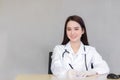 A professional Asian female doctor writes a document in a hospital clinic examination room at the hospital health care concept Royalty Free Stock Photo