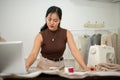 A professional Asian female fashion designer or tailor is focusing on her work in the atelier studio Royalty Free Stock Photo