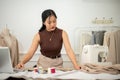 A professional Asian female fashion designer or tailor is focusing on her work in the atelier studio Royalty Free Stock Photo