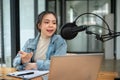 A professional Asian female radio host announcing or sharing interesting news with her audience