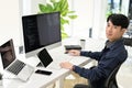 Professional Asian male programmer sits at his office desk, smiling at looking at the camera Royalty Free Stock Photo