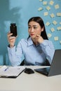 Asian woman at office desk looking a container of pills Royalty Free Stock Photo