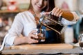 Professional Asian woman Barista preparing coffee at front counter serving coffee cup