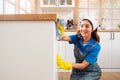 Professional Asian woman cleaning service wearing yellow rubber gloves, using a rag to wipe with spraying liquid detergent. Royalty Free Stock Photo