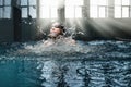 Professional athlete swims in the breaststroke in the pool