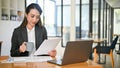 Professional Asian businesswoman reading a document, examining financial report Royalty Free Stock Photo