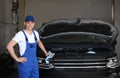 Auto mechanic near modern car in service center Royalty Free Stock Photo