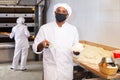 Baker dividing raw dough into equal parts in bakery