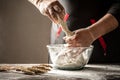 Professional baker kneads dough in glass bowl on table in bakery kitchen. Baking concept