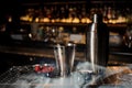 Professional bar equipment, shaker, glass and tongs arranged on the bar counter with fume