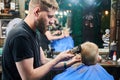 Professional barber concentrated on his work. Royalty Free Stock Photo