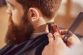 Professional barber cutting hair of his client