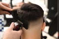 Professional barber making stylish haircut in salon