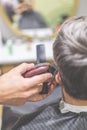 Professional barber styling hair of his client by using comb and clipper Royalty Free Stock Photo