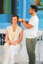 Professional barbre styling a young female model's hair in a salon in Cape Town, South Afric