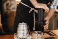 Professional barista preparing coffee in aeropress, alternative coffee brewing method. Hands on aeropress and glass cup, scales,