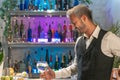 Professional barman looking cocktail in nightclub. Night life concept
