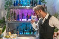 Professional barman smelling cocktail in nightclub. Night life concept
