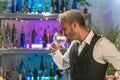 Professional barman tasting cocktail in nightclub. Night life concept