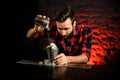 Professional bartender adding sugar powder to steel glass.