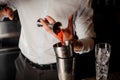 Professional bartender adding a transparent red alcoholic drink into the steel shaker Royalty Free Stock Photo