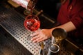 Bartender girl pouring the last straw of a delicious campari cocktail Royalty Free Stock Photo