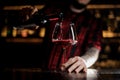 Professional bartender pourring a delicious wine from a bottle t