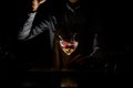 Professional bartender throwing a red rose bud to a martini glass with a cocktail in the dark Royalty Free Stock Photo