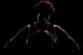 Professional basketball player holding a ball against black background. Serious concentrated african american man Royalty Free Stock Photo