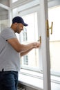 Professional handyman fixing window handle at home. Royalty Free Stock Photo