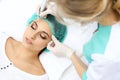 Professional beautician doing eyebrow tattoo at woman face. Permanent brow makeup in beauty salon, closeup. Cosmetolog Royalty Free Stock Photo