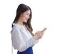 Professional beautiful confident young Asian businesswoman stands while uses her smartphone to send messages to office isolated on Royalty Free Stock Photo