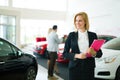 Professional saleswoman working in car dealership Royalty Free Stock Photo