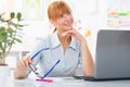 Professional beautiful young woman sitting her desk an holding glasses in her hands Royalty Free Stock Photo