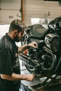 Professional bike mechanic checks the level of oil in the motorcycle.